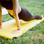 woman in black shorts and black stockings lying on yellow surfboard