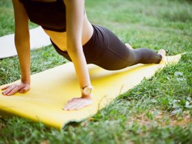 woman in black shorts and black stockings lying on yellow surfboard
