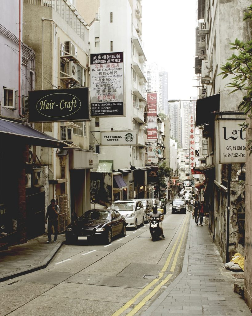 cars parked on sidewalk near buildings during daytime