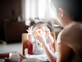selective focus photography of woman feeding baby