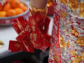 a close up of a person holding a red ribbon