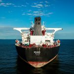red and black ship on sea under blue sky during daytime