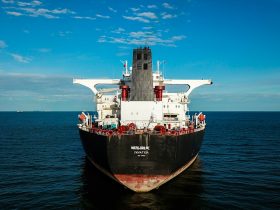 red and black ship on sea under blue sky during daytime