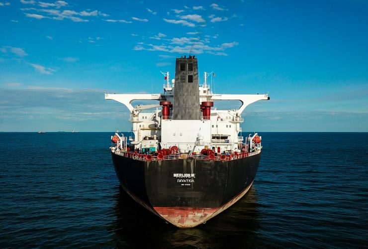 red and black ship on sea under blue sky during daytime