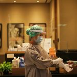 person in white dress shirt wearing green and white hat