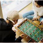 man and woman playing foosball table