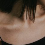 a close up of a woman wearing a black top
