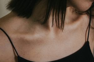 a close up of a woman wearing a black top