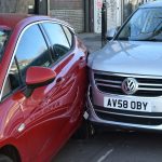 two cars parked next to each other in a parking lot