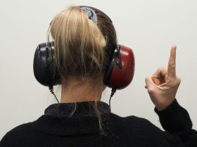a woman wearing headphones pointing to the side